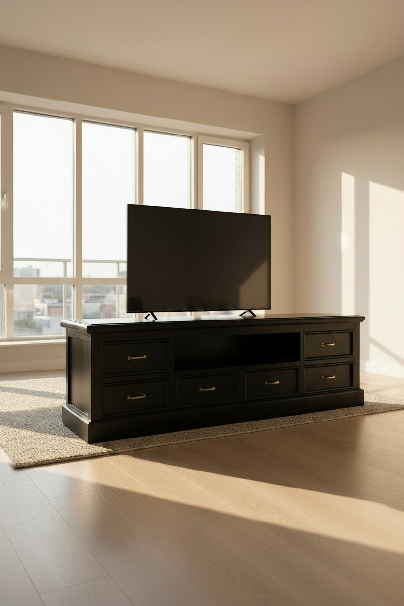 A black TV cabinet with six drawers, decorated with a floral pattern on the wall behind it.